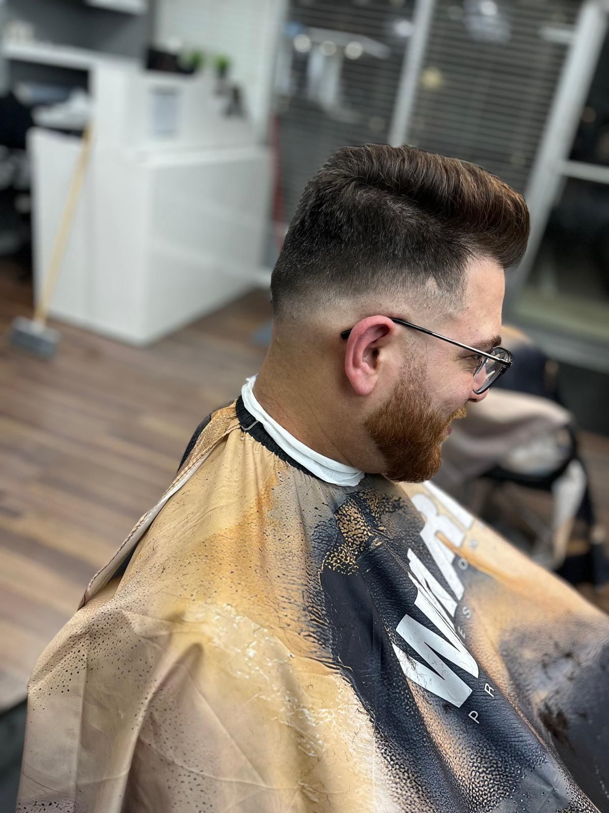 Pompadour with a skin fade and a full red beard