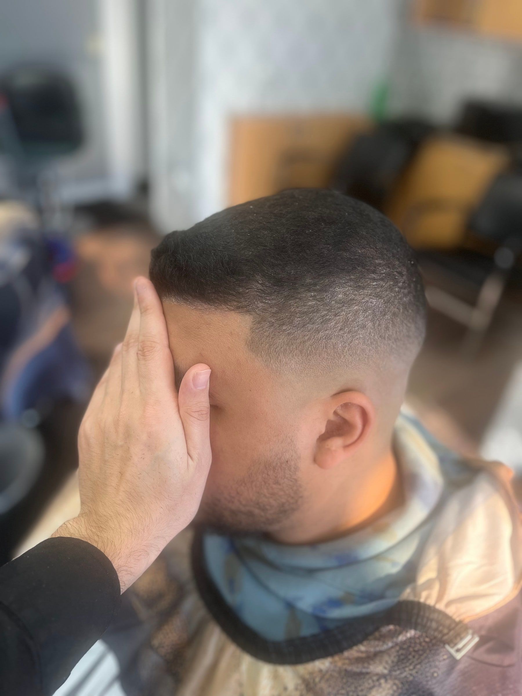 Mid skin fade with a clean line-up at the temple